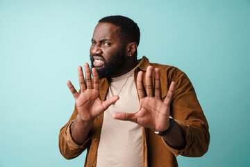 Displeased african american man showing stop gesture at camera
