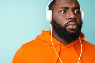 Unshaven african american man listening music with headphones