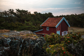 Rotes Haus im Wald zwischen Felsen in Schweden.