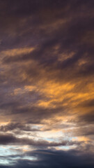 Magnifique ciel jaune pendant le coucher du soleil, alors que des gros cumulus masquent partiellement le soleil