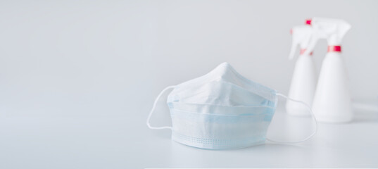 Medical face mask with alcohol disinfectant gel bottle for washing hands. Panner for covid-19 coronavirus prevention concept with free space.