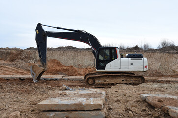 Excavator during earthmoving at construction site. Backhoe dig ground for the construction of...