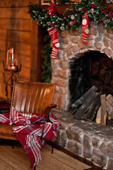 Interior decorated for Christmas. Armchair and fireplace with socks.