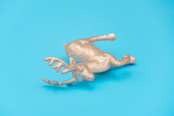 Lying silver deer on the blue background. Christmas reindeer