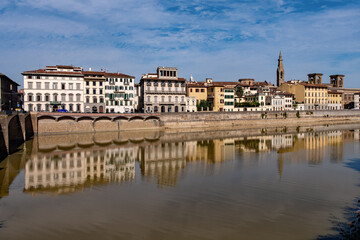 Fototapeta na wymiar Row of houses reflecting in the Arno River at the old town of Florence, Tuscany Region in Italy 