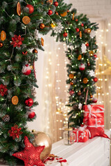 Christmas gifts and a big red ball lie under a fir garland decorated with snowflakes balls of dried oranges. the boxes are decorated with ribbons. New year cozy background. beautiful postcard