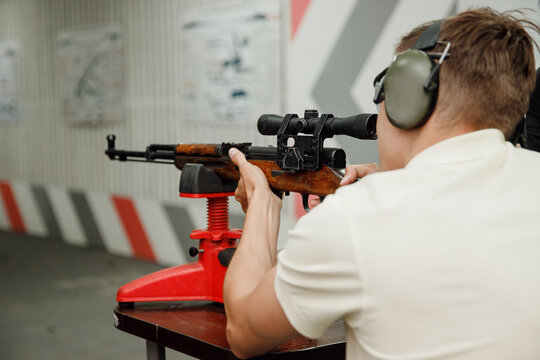 Man directs firearm gun pistol at target firing range or shooting