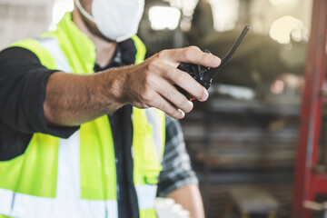 The factory worker pointing a radio communication.