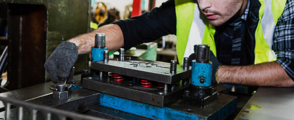 A male engineer checks the machine in the factory.