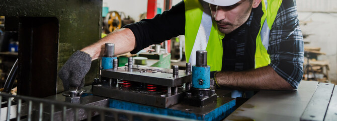 A male engineer checks the machine in the factory.