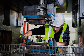 A male engineer checks the machine in the factory.
