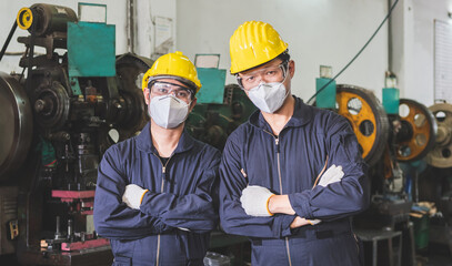 Workers in uniforms crossed arms in the factory.