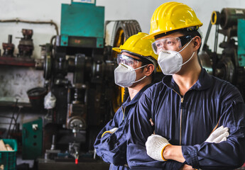 Workers in uniforms crossed arms in the factory.