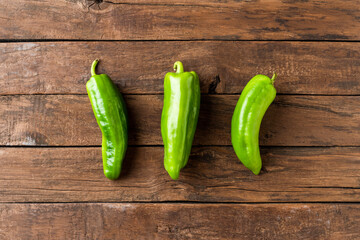 Overhead shot of organic green pepper on wooden background