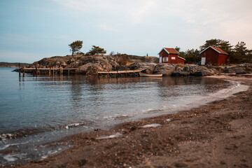 Fototapeta na wymiar Rotes Haus in Schweden am Meer mit Sandstrand. 