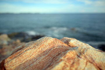 The brown rocks by the sea are on the background of the sea and