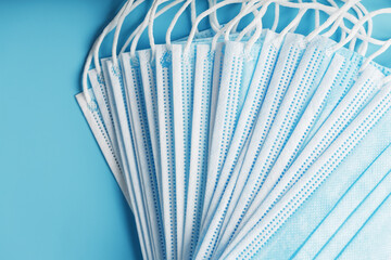 Medical protective masks on a blue background are stacked.
