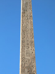 ancient egyptian obelisk with many engraved hieroglyphs and sky
