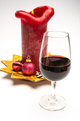Popular british christmas drink, glass of vintage ruby port wine and candle with christmas tree decoration