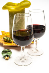 Popular british christmas drink, glass of vintage ruby port wine and candle with christmas tree decoration