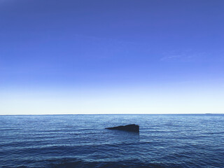 stone in the sea, peaceful blue seascape background