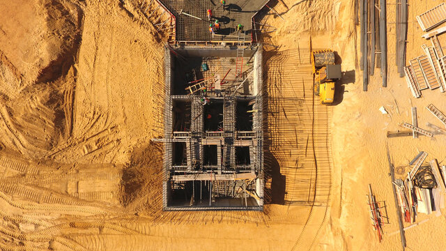Hombres trabajando en planta de construcci&oacute;n de estructura hormigonada