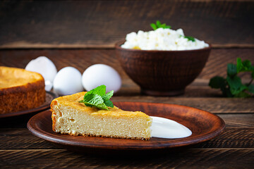 Homemade cottage cheese casserole on rustic wooden background