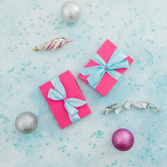 Christmas concept of pink gift box and decoration on blue background. Winter holiday composition. Flat lay