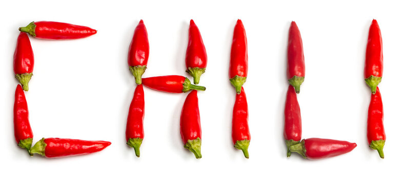 Word chili made up of fresh red peppers on white background
