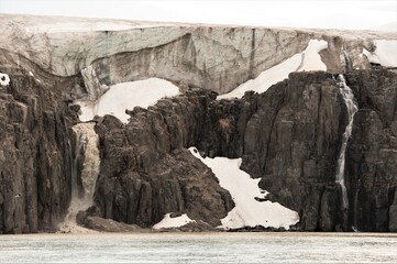 Die Gletscherschmelze infolge der Erderwärmung ist ein globales Phänomen. - Vergletscherter Küstenabschnitt an der Steilküste von Spitzbergen
