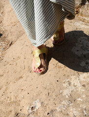 Woman with sandals while walking in the roman street with an anc
