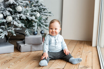 A cute baby boy near Christmas tree