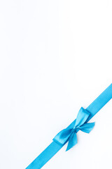 Blue ribbon with bow isolated on white. Top view, copy space