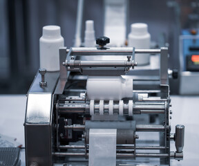 White bottle on labeling machine in pharmaceutical industrial