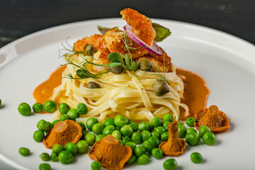 Close-up pasta and fried shrimps with green peas and original chanterelle sauce. Healthy and tasty food. Chef Original Recipe.