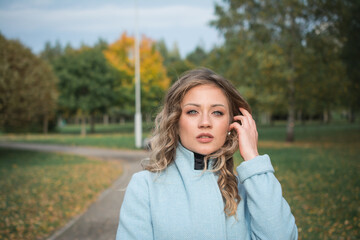 An elegant girl in autumn clothes in an autumn park