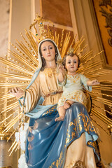 Virgin Mary with the baby Jesus in her arms. Wood carving of the Virgin Mary and baby Jesus in a...