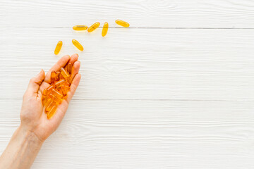 Omega fish cod liver oil capsules in hands, copy space