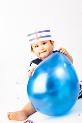 happy cute baby boy wearing sailor costume with balloon