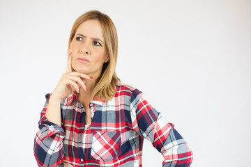 Young woman in casual clothes standing over white isolated background clueless and confused...