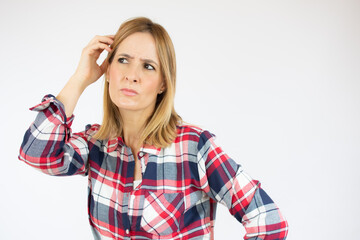 Young woman in casual clothes standing over white isolated background clueless and confused...