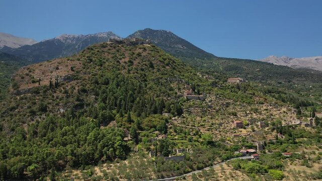 Aerial drone video of medieval byzantine old city of Mystras featuring Monastery of Pantanassa, Temple of Agia Sofia and uphill castle of Mystras, Sparta, Peloponnese, Greece