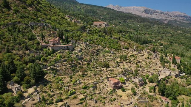 Aerial drone video of medieval byzantine old city of Mystras featuring Monastery of Pantanassa, Temple of Agia Sofia and uphill castle of Mystras, Sparta, Peloponnese, Greece