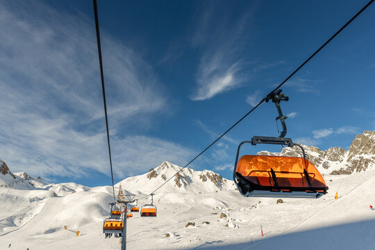 Scenic panoramic view of Silvretta ski area at Iscgl and Samnaun skiing resort with chairlifts , downhill slpoes and clear blue sky on background. Winter sport travel recreation and activities