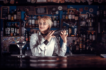Focused woman tapster intensely finishes his creation in pub