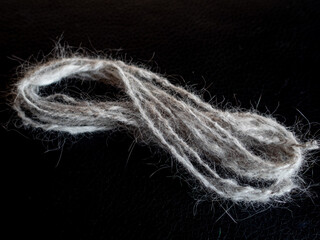 tiny skein of handspun cat wool on a black background