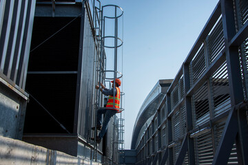 construction workers on a site. engineer under checking the industry cooling tower air conditioner...