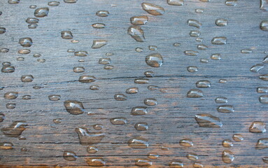 Water drops, raindrops pattern on wooden bench planks. Shallow depth of field.