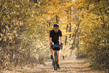Bicycle tourism: man rides a touring bike through the forest. Bi