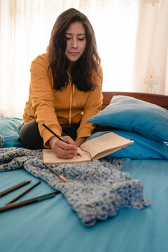 Girl drawing in the bed in quarantine